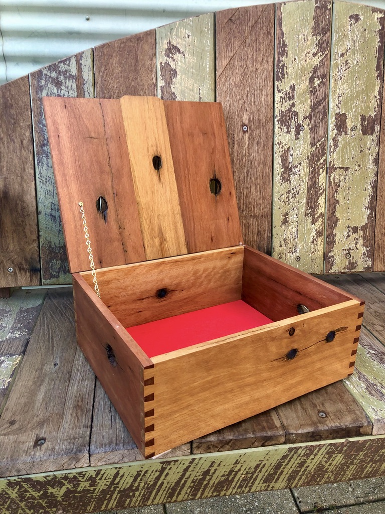 A mahogany box featuring the holes where the wire used to go through the fence posts